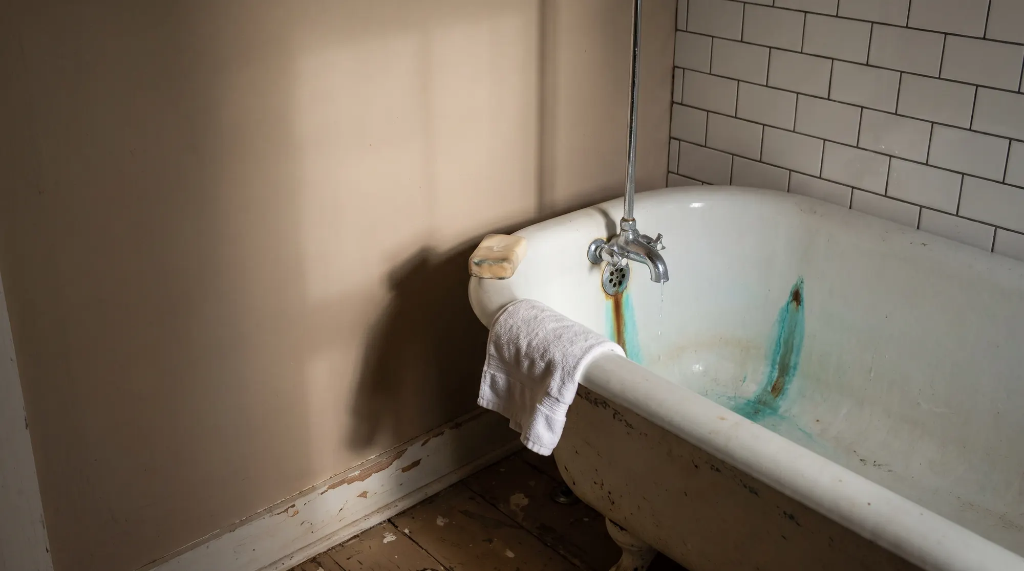AI-generated illustration of a white farmhouse bathtub with a blue-green copper stain running from a dripping faucet toward the drain